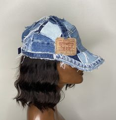 a mannequin's head wearing a denim hat with an embroidered label on it