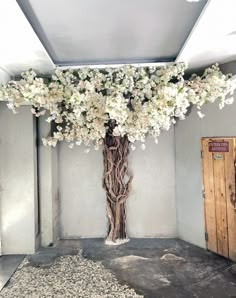 a tall vase with white flowers is in the middle of an empty room next to a door