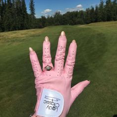 a pink glove with a ring on it in the middle of a golf course,