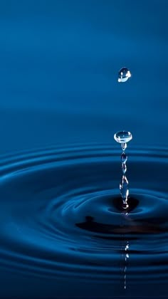 a water droplet is shown in the middle of a blue pond with ripples