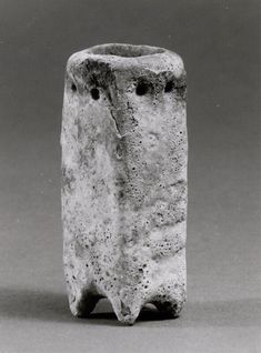 a black and white photo of a vase with two holes in the middle of it