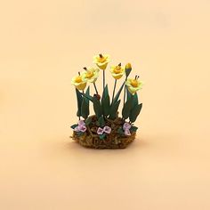 some yellow flowers are in a small pot