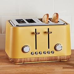 a yellow toaster sitting on top of a wooden table