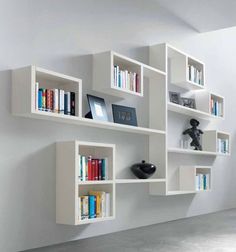 the bookshelves are all white and have many different types of books on them