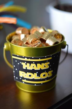 a bucket filled with gold foil sitting on top of a table