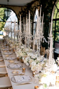 a long table is set with candles and flowers on it for an elegant wedding reception