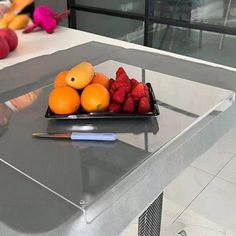 a tray of fruit sitting on top of a glass table