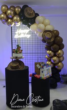 balloons and presents are on display in front of a wall with an arch made out of black pillars