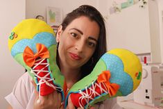 a woman holding up two colorful pillows in front of her face with the caption sapato de palhaco