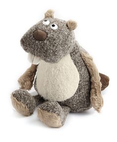 a stuffed hippo sitting on the ground with one eye open and two legs crossed