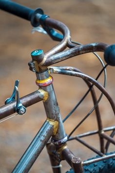 an old bicycle with rust on the front wheel and seatposts is seen in this image