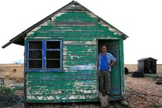 a man standing in the doorway of an outhouse