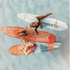 three people laying on surfboards in the water with one person upside down and another standing up