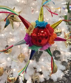 an ornament is hanging on the tree in front of a white christmas tree