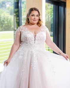 a woman in a wedding dress posing for the camera with her hands on her hips