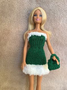 a barbie doll wearing a green dress and holding a handbag on a white background