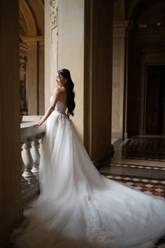 a woman in a wedding dress leaning against a wall