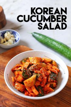 korean cucumber salad in a white bowl on a wooden cutting board