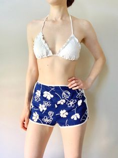 *A California Poppy by Lanz beach shorts from the 1960s *Dolphin shorts style with brief-style lining *50% polyester/50% cotton This fun pair of vintage beach shorts has a bright blue and white tropical print. The white brief-style lining has elastic at the bottoms. The shorts zip up the back and have a button loop at the top. These are great for strolling along the boardwalk or wearing over a swimsuit! Label: A California Poppy by Lanz, Cut 55-91, Style 8437, Made in U.S.A. Size: Small, tagged size 10 * Measurements * Waist: 26" Hips: 35" Length (top to crotch): 25" Material has no stretch. (Bust, waist and hip measurements are approximate, taken from seam to seam with garment laying flat and doubled. Model typically wears size small in swimwear.) Condition: Good vintage condition. A hori Summer Swimwear With Built-in Shorts For Summer Outings, Beachy Cotton Shorts For Beach Party, Short Swim Trunks For Spring Beach Party, Spring Beach Party Swim Trunks, Summer Cotton Bottoms For Beach Party, Cotton Shorts For Beach Party, Summer Shorts For Beach, Cotton Beachwear Pajama Shorts For Poolside, Beachy Cotton Bottoms For Beach Party