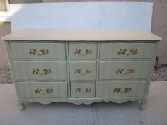 a white dresser with gold handles and drawers