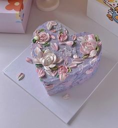 a heart shaped box with flowers on it