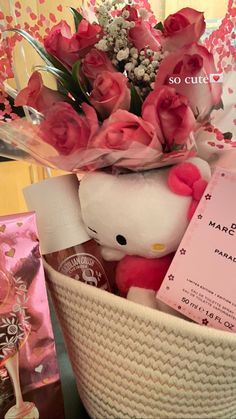 a basket filled with pink roses and a hello kitty stuffed animal next to a card