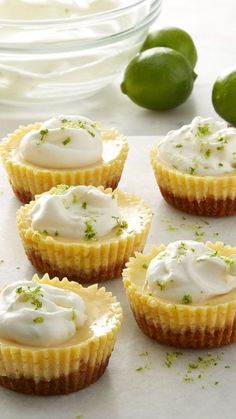 small tarts with white icing and limes on the side