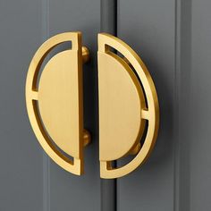 a close up of a door handle on a gray door with gold rings and handles