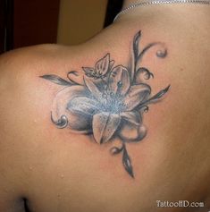 a woman's back with a flower tattoo on it