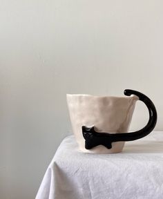 a white and black cup sitting on top of a table