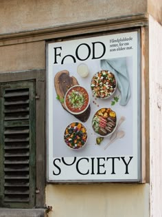 a sign on the side of a building that says food society with pictures of different foods