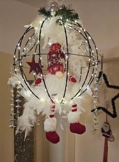 a christmas ornament hanging from the ceiling with lights and decorations on it's sides