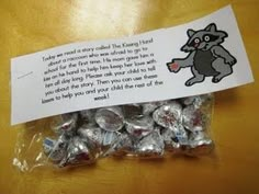 a bag filled with chocolate candies sitting on top of a wooden table next to a note