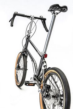 a black and silver bike with brown rims on it's front wheel, against a white background