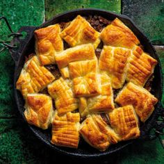 a pan filled with lots of food on top of a green floor