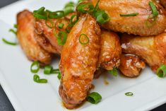 chicken wings with green onions on a white plate