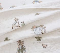 an unmade bed covered in white sheets with bugs and mice on them