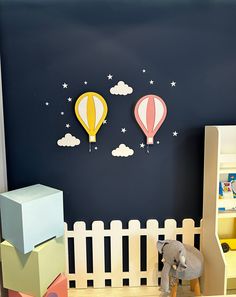 two hot air balloons are on the wall next to a toy elephant and bookshelf