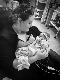 a woman sitting in a chair holding a baby