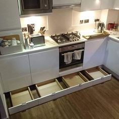 an open drawer in the middle of a kitchen