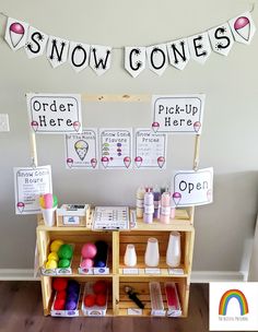 a table with craft supplies on it and some signs hanging from the wall behind it