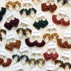 several pairs of earrings are displayed on a white surface with price tags attached to them