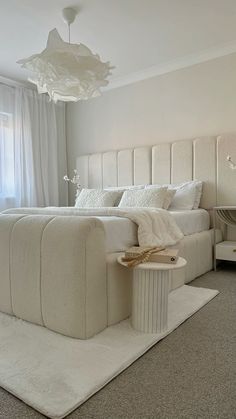 a bedroom with a large bed and white furniture