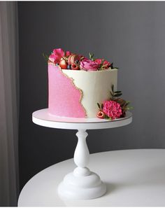 a pink and white cake with flowers on top