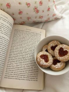 some powdered sugar cookies in a bowl next to an open book