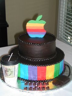 a triple layer cake with an apple on top and a cup of coffee next to it