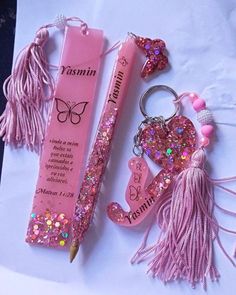 a pink pen and keychain are laying next to each other