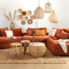 a living room filled with lots of orange couches and pillows on top of a rug