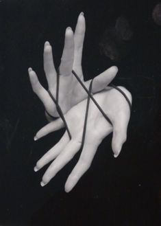 a pair of hands tied together with black string