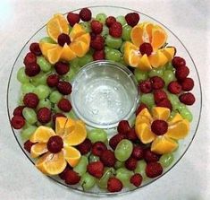 a glass plate filled with fruit on top of a table